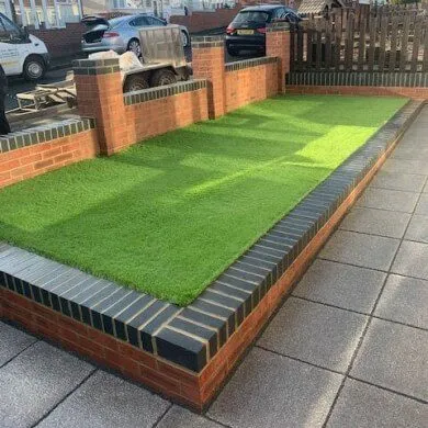landscaped front garden with stone wall surrounding